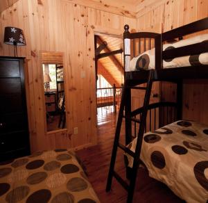 a bedroom with two bunk beds in a cabin at Le Chalet Bois Rond Relax in Saint-Tite-des-Caps +8 photos