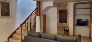 a living room with a couch and a staircase at L'instant doré in Charnay
