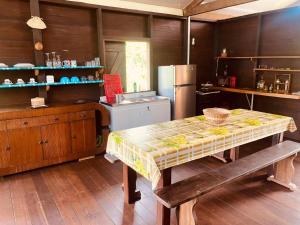 a kitchen with a table and a refrigerator at lakazatypique in Saint-Laurent du Maroni +9 photos