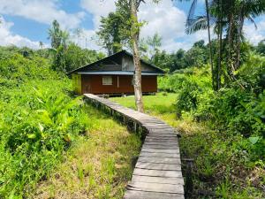 a wooden path leading to a small house at lakazatypique in Saint-Laurent du Maroni