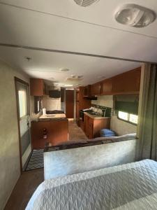 an rv bedroom with a bed and a kitchen at Motel de L'Anse et Camping Rimouski in Rimouski