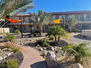 a courtyard with palm trees and a building at RELAX hotel and spa in Desert Hot Springs