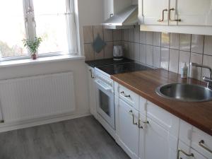 a kitchen with white cabinets and a sink at Fuglevænget in Hundested