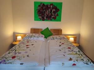 a bedroom with two beds and a green painting on the wall at Designer Apartement mit Kamin in Hartberg