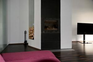 a living room with a fireplace and a tv at Designer Apartement mit Kamin in Hartberg