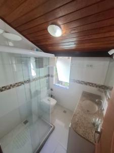 a bathroom with a glass shower and a toilet at Pousada Colibris da Barra da Tijuca in Rio de Janeiro +42 photos