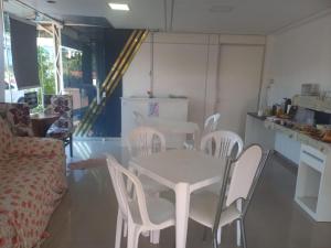 a white table and white chairs in a kitchen at Pousada Romelandia in Romelândia +16 photos
