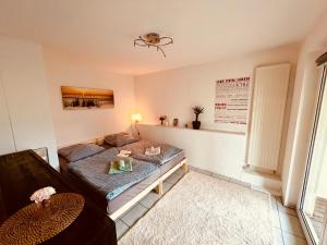 a living room with a bed and a couch at Ferienwohnung momentglücklich in Eggingen in Eggingen