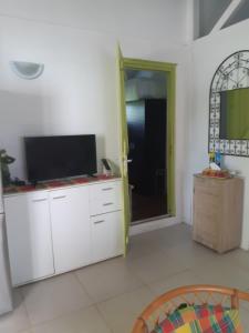a living room with a flat screen tv on a counter at Gîte HIBISCUS in Saint-François