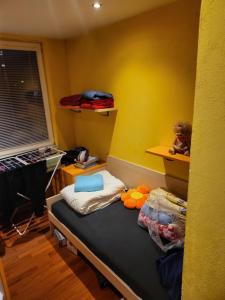 a small room with a bed and a yellow wall at Snp 18 luxury in Košice
