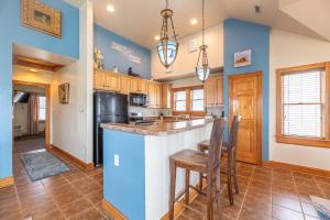 a kitchen with blue walls and a counter and chairs at Happy Dog Days - Nags Head MP 11, Ocean View, 50 Yds to Beach, Elevator, Pool, Hot Tub, Pets OK, Flex Stays in Nags Head