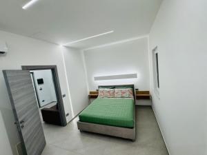a small bedroom with a green bed and a mirror at Ponente Amato Home in Gaggi