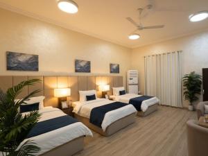 two beds in a hotel room with two lamps at sea breeze RAK in Ras al Khaimah