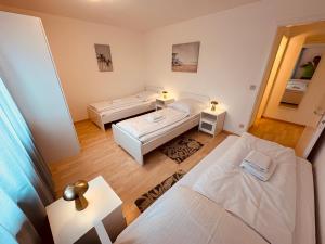 a small room with two beds and two tables at 3-Room Apartment Up to 5 Guests Family Business Free WiFi Netflix Sky DAZN Disney Plus 1000 International TV Channels in Wynau