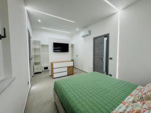 a bedroom with a green bed and a desk at Ponente Amato Home in Gaggi