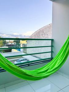 a green hammock on a balcony with a view at APË GOLD NO CENTRO DA CIDADE COM AR E CAMA KINg in Formosa