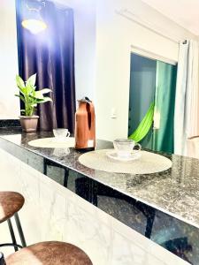a kitchen counter with two chairs and a kettle on it at APË GOLD NO CENTRO DA CIDADE COM AR E CAMA KINg in Formosa +87 photos