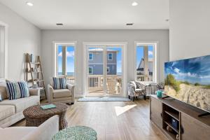a living room with a couch and a tv at Pet Friendly Beach House with Private Pool - Bella View in Port Saint Joe