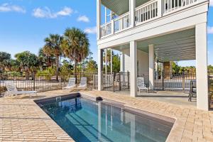 a swimming pool in front of a house at Pet Friendly Beach House with Private Pool - Bella View in Port Saint Joe