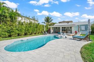 a swimming pool in front of a house at Private Pool, Backyard, and Steps to the Beach in Cocoa Beach