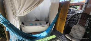 a bath tub in a hammock in a room at CASA CLIMATIZADA COM HIDROMASSAGEM PRÓXIMO BETO CARRERO E PRAIAS - Casa 1 DuMar Hospedagem in Penha
