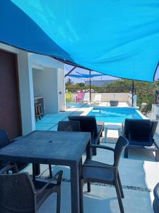a patio with a table and chairs and a swimming pool at Nautica Apartment-4 guests and shared pool in Isla Mujeres