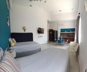a bedroom with two beds and a dining room at Nautica Apartment-4 guests and shared pool in Isla Mujeres +24 photos