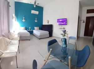 a living room with a glass table and blue walls at Nautica Apartment-4 guests and shared pool in Isla Mujeres