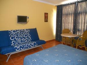 a living room with a blue couch and a table at Apartamentos la Atarraya in Zahara de los Atunes