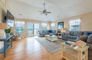 a living room with a couch and a table at Serenity in Nags Head - MP 11, Oceanfront, Ocean View, Pool, Hot Tub, Pets OK, YR Flex Stays in Nags Head
