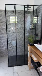 a glass shower door in a room with a brick wall at Villa zion in Deshaies