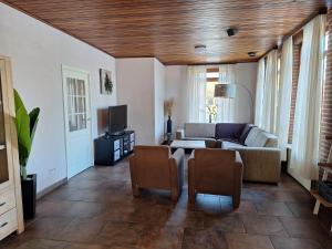 a living room with a couch and a tv at Liroja's Vakantiehuis in Vlagtwedde