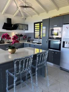 a kitchen with a counter with chairs and a refrigerator at Villa zion in Deshaies +26 photos