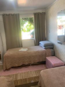 two beds in a room with a window and a window at Pousada Romelandia in Romelândia