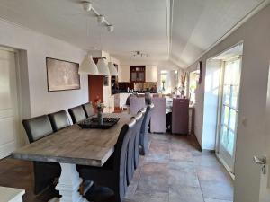 a dining room with a wooden table and chairs at Liroja's Vakantiehuis in Vlagtwedde
