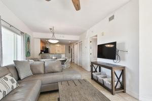a living room with a couch and a flat screen tv at Sunsets & Coastal Vibes Treasure Island Stay in St. Pete Beach