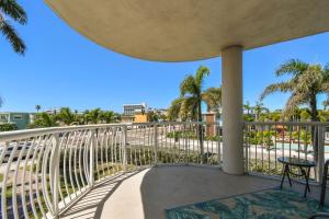 a balcony with a view of the beach and palm trees at Sunsets & Coastal Vibes Treasure Island Stay in St. Pete Beach +42 photos