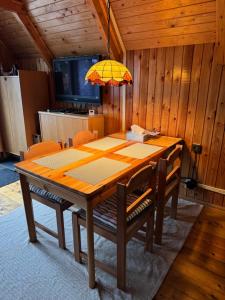a dining room table with chairs and a yellow umbrella at chata u Ondrucha in Tři Studně +11 photos
