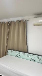 a bed in a small room with a curtain at Casa praia 99 in Serra
