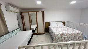 a small room with a bed and a mirror at Casa praia 99 in Serra