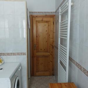 a bathroom with a wooden door and a washing machine at Il Paradiso Della Montagna in Cutigliano +22 photos