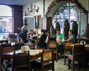 a group of people sitting at tables in a restaurant at Hotel San Miguel in Morelia