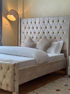a bedroom with a bed with a tufted headboard at TMT Homes in Nairobi