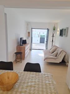 a living room with a table and a couch at Apartamento Can Rupit Playa Santandria con jardin y piscina in Son Carrio +63 photos