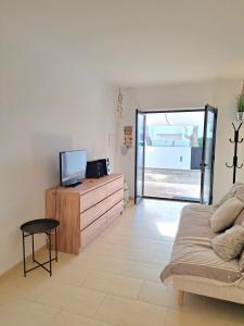 a bedroom with a bed and a tv on a dresser at Apartamento Can Rupit Playa Santandria con jardin y piscina in Son Carrio