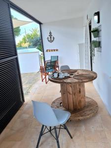 a room with a table and chairs and a patio at Apartamento Can Rupit Playa Santandria con jardin y piscina in Son Carrio
