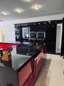 a kitchen with black cabinets and a red counter top at Sea Whisper Villa in Dobra Voda