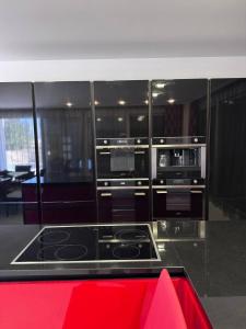 a kitchen with a stove and a red island at Sea Whisper Villa in Dobra Voda +59 photos