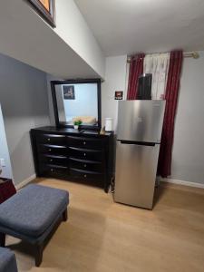 a living room with a refrigerator and a dresser at Executive private room in Irvington