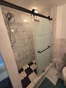 a shower with a glass door in a bathroom at Executive private room in Irvington